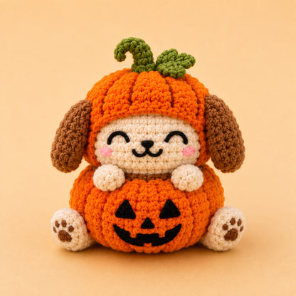 Handmade crochet puppy dumpling plush in an orange pumpkin hat with a jack-o-lantern belly