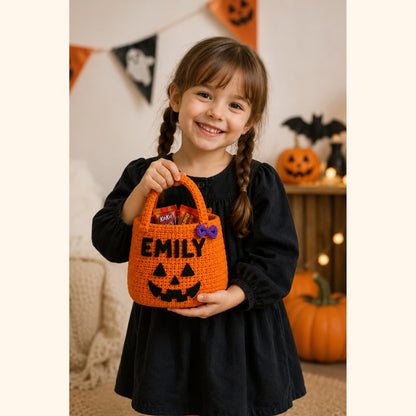 Smiling child holding an orange personalized crochet pumpkin candy bag on Halloween night